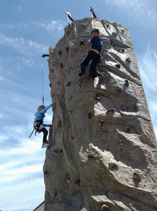 Two participants climbing different routes on a Climb On mobile wall
